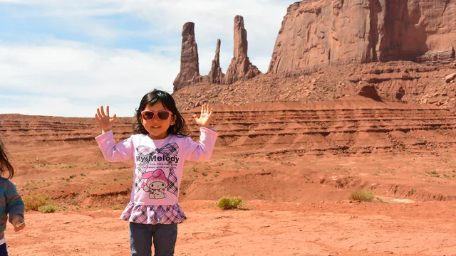 アメリカ在住時、赤い岩山を背景に両手を上げる3〜4歳のころの生徒さん